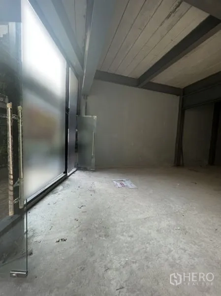 Retail Space for rent in Watthana, Bangkok - Unfinished retail area with concrete floor, floor-to-ceiling frosted glazing and a glass entrance door.