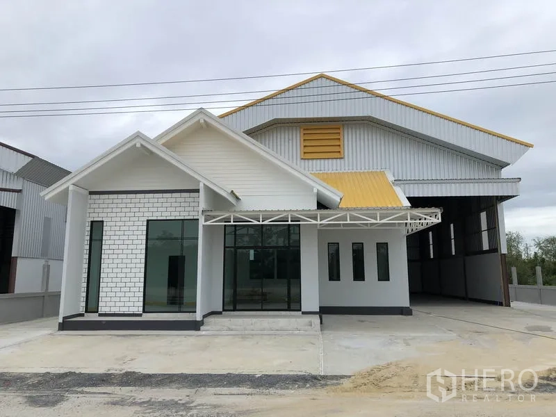 Factory for rent or sale in Sai Noi, Nonthaburi - Front view of a newly built factory with attached office, glass frontage and yellow-accent metal roof.
