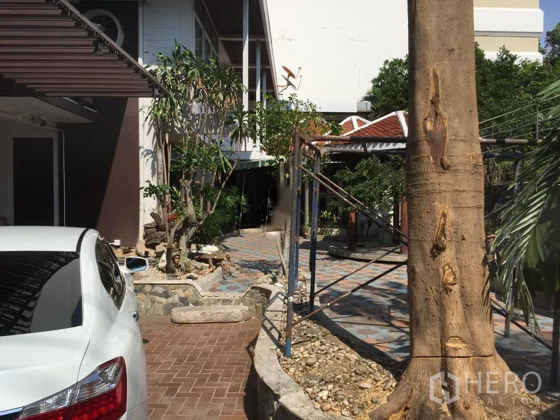 Retail Space for rent in Khlong Toei, Bangkok - Courtyard garden with mature trees, stone paths and seating beside the main building.