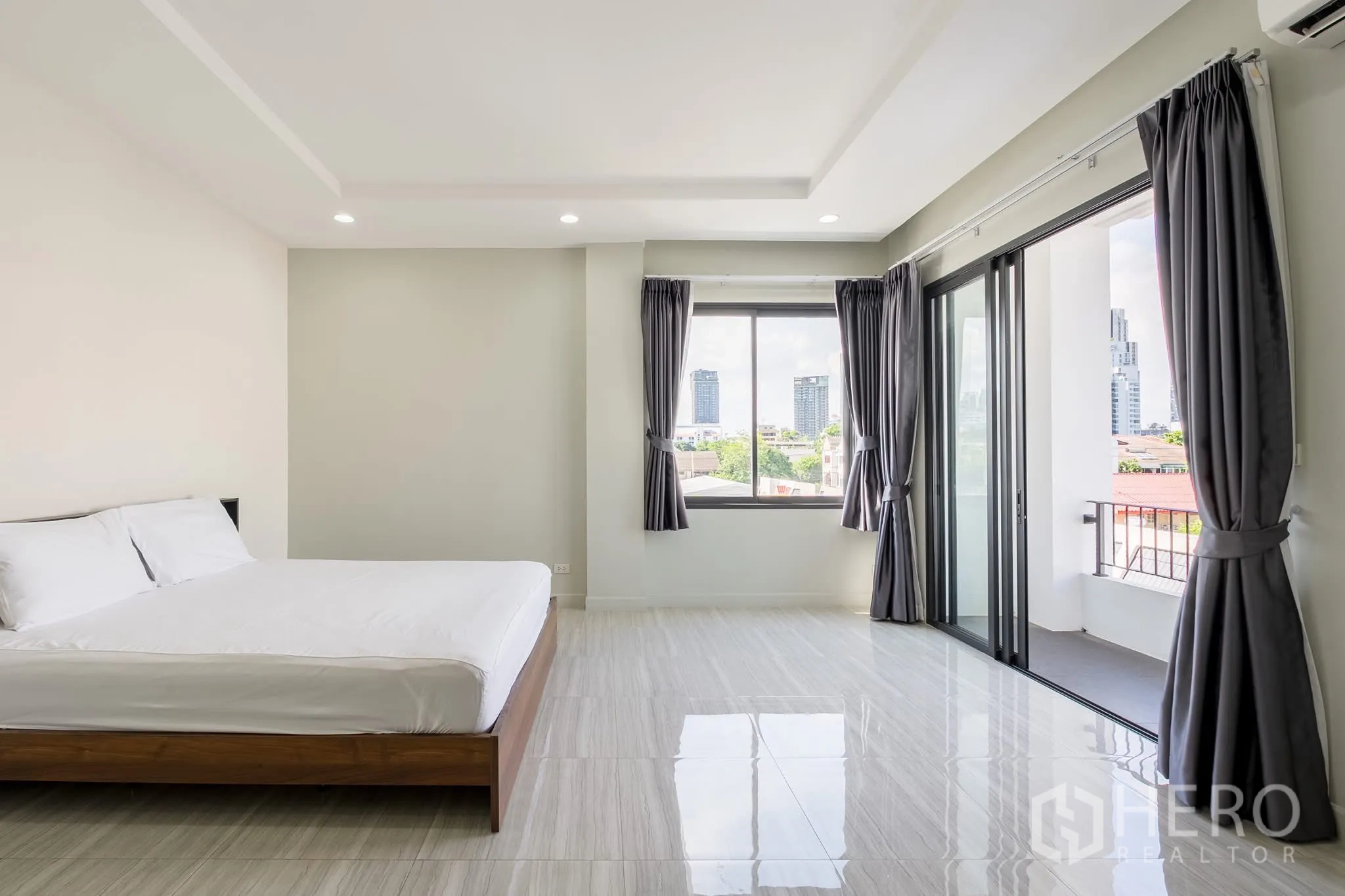 Home Office for rent in Khlong Toei, Bangkok - Spacious bedroom with balcony access, corner windows and city outlook.