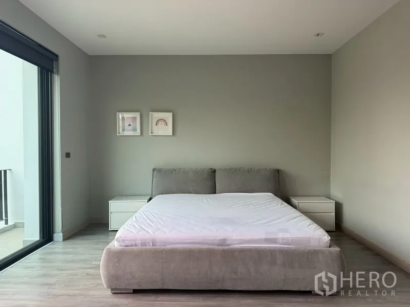 บ้านแฝด for rent in Watthana, Bangkok - ห้องนอนสไตล์มินิมอลมีเตียงและตู้ข้างเตียงติดระเบียง