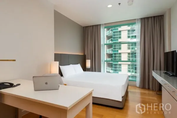 Condominium for rent in Bang Kho Laem, Bangkok - Bright master bedroom with king bed, work desk and large window overlooking a neighboring tower.