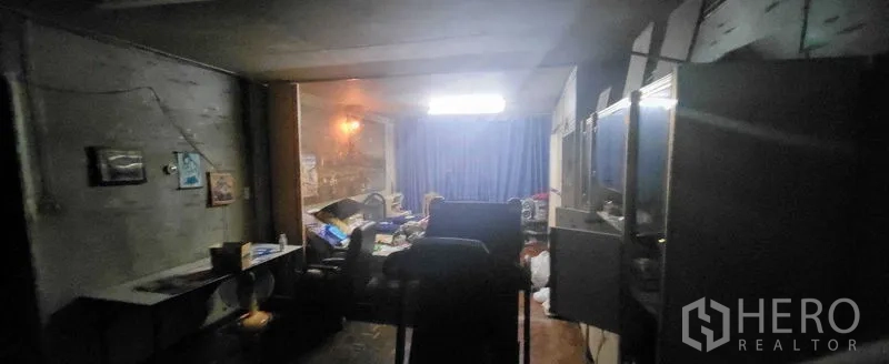 Shophouse for rent in Khlong Toei, Bangkok - Large upper-floor living area with window and curtain, suitable for conversion.