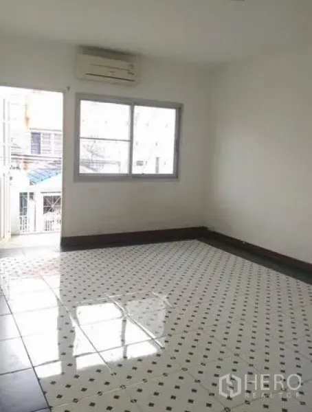 联排别墅 出租在Wang Thonglang, Bangkok - 卧室带阳台门与窗户，光亮图案瓷砖地面并设空调。