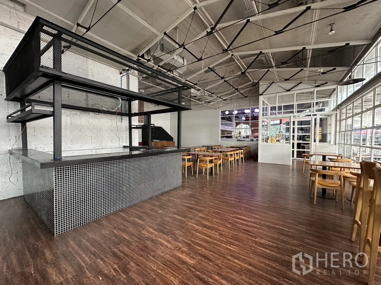 Retail Space for rent in Watthana, Bangkok - Wide view of the retail area showing counter island, tables, and truss ceiling.