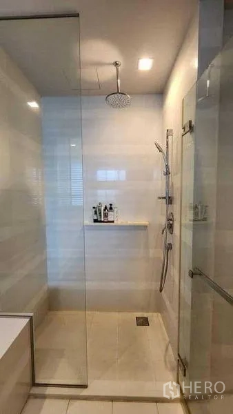 Condominium for rent in Khlong Toei, Bangkok - Glass shower with rain shower head and handheld sprayer.
