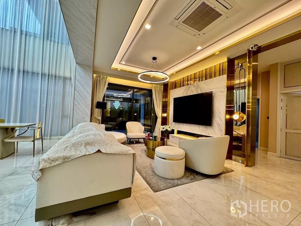 Detached House for sale in Saphan Sung, Bangkok - Luxury family lounge with marble feature TV wall, gold accents and modern sofa set.