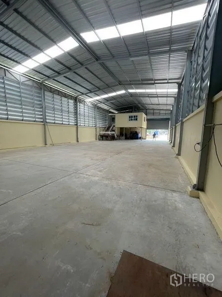 คลังสินค้า ให้เช่าในLam Luk Ka, Pathum Thani - มุมลึกภายในโกดัง เห็นออฟฟิศชั้นลอยและประตูโหลดด้านหน้า
