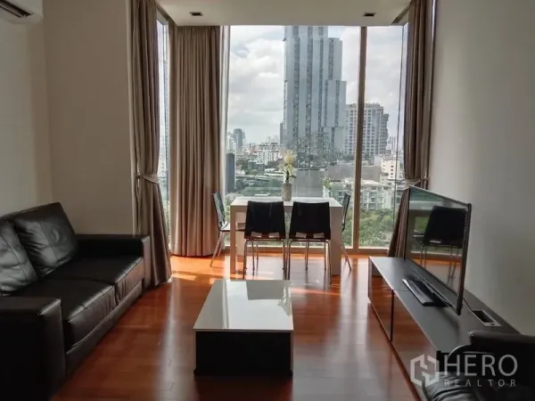 Condominium for rent - Bright living room with sofa, TV console and dining set framed by wide city views.