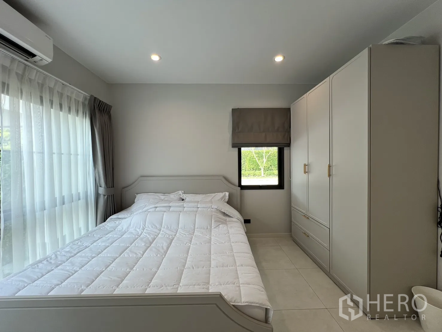Detached House for rent in Bang Phli, Samut Prakan - Cozy bedroom with built-in wardrobe, air conditioner and garden-view windows.