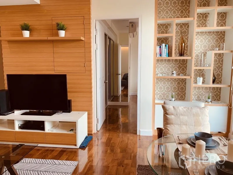 公寓 出租在Watthana, Bangkok - 电视墙与装饰置物架，旁边是通往卧室的走廊