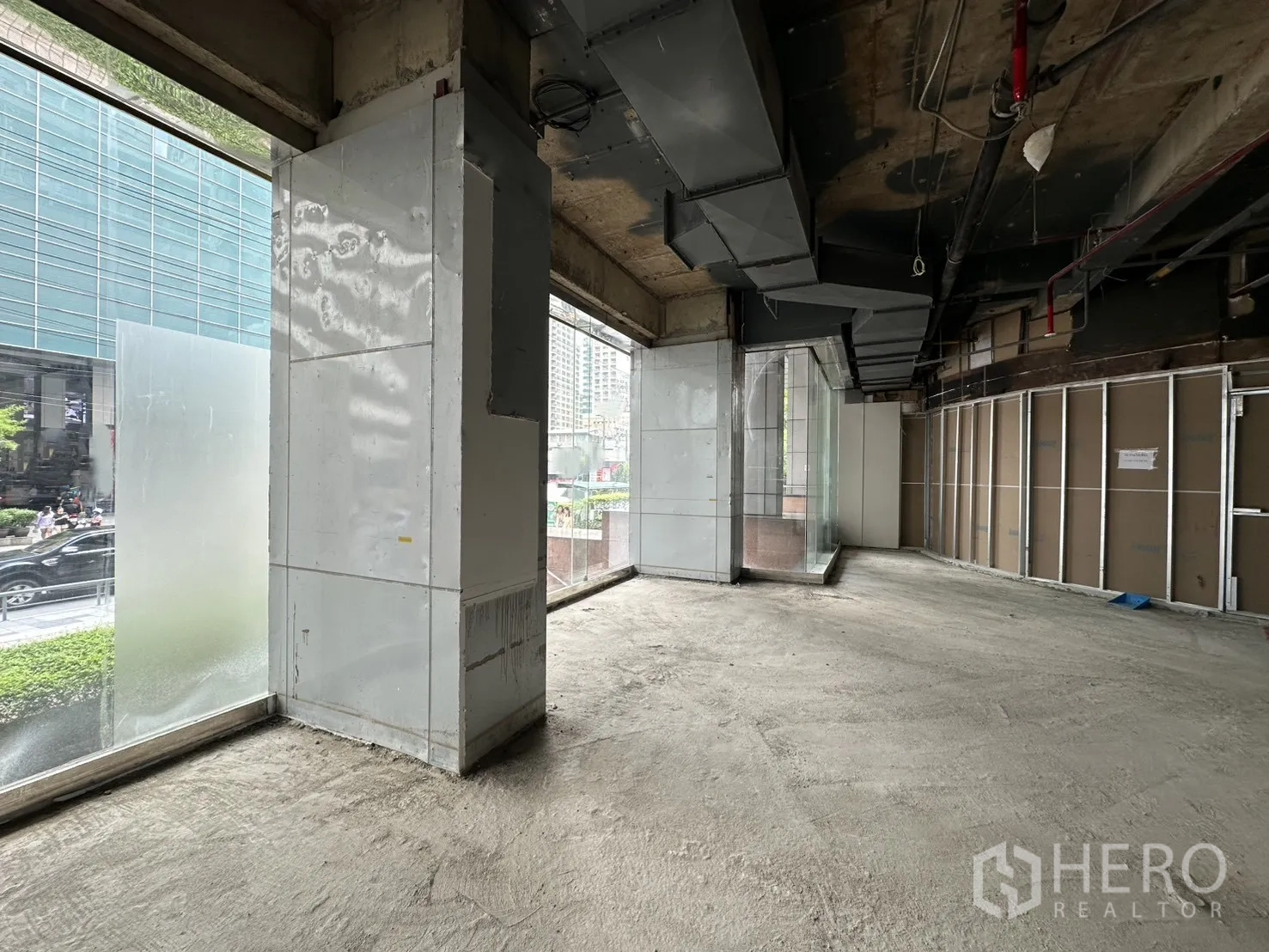零售空间 for rent in Watthana, Bangkok - 角部零售空间，超大玻璃门面与空调风管可见。