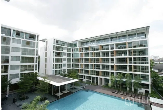 Condominium for sale in Khlong Toei, Bangkok - Contemporary low-rise condominium buildings surrounding a large central pool.