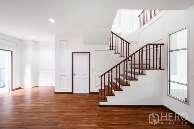Townhouse for sale - Stairwell with wooden balustrade connecting multiple levels.