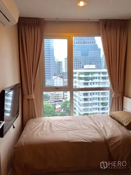 公寓 出租在Sathon, Bangkok - 卧室单人床，落地窗可观沙吞天际线城市景观。