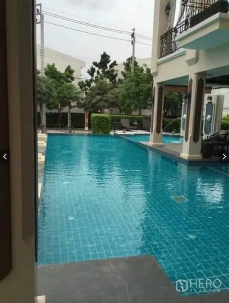 Townhouse for rent or sale in Suan Luang, Bangkok - Communal swimming pool with shaded pavilion and seating in the residential compound.