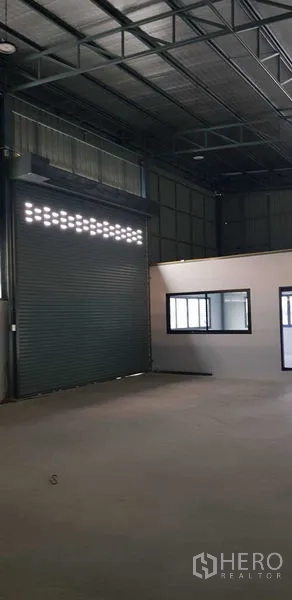 货栈 出租在Lat Lum Kaeo, Pathum Thani - 内部视角：带采光孔的卷帘门与办公室窗户。