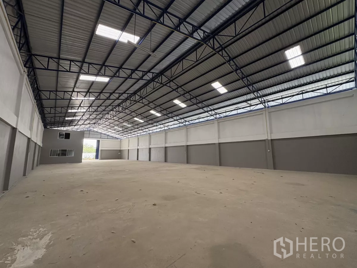 Warehouse for rent in Mueang Samut Prakan, Samut Prakan - Reverse angle showing the loading entrance and office block at the far end of the hall.