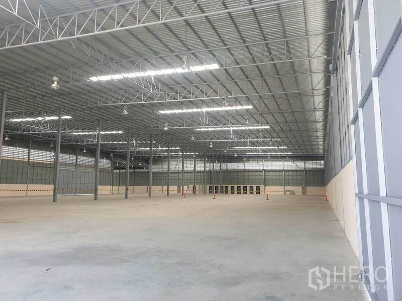 货栈 出租在Chachoengsao - 高钢结构屋顶带采光天窗的超大仓库空间，地面为平整混凝土。