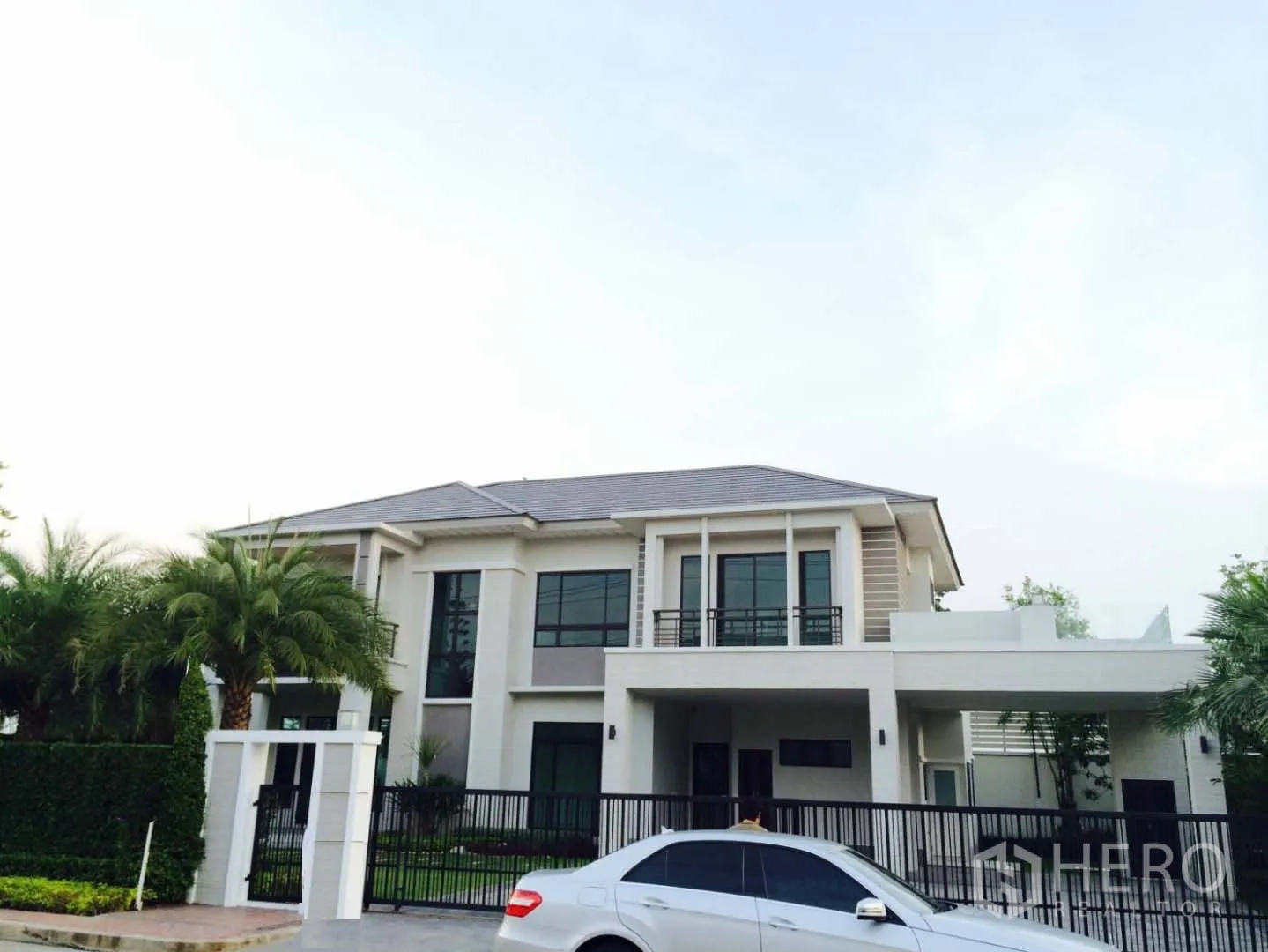 Detached House for sale in Lat Krabang, Bangkok - Front elevation of a contemporary two-storey house with gated driveway and covered carport.