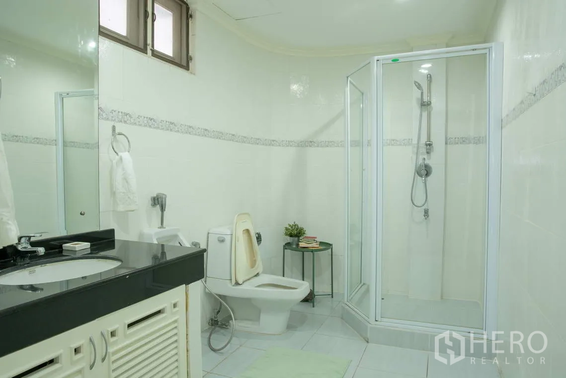 อพาร์ทเมนท์ for rent in Khlong Toei, Bangkok - ห้องน้ำมีตู้ชาวเวอร์กระจก โถสุขภัณฑ์ และอ่างล้างหน้าเคาน์เตอร์กว้าง.