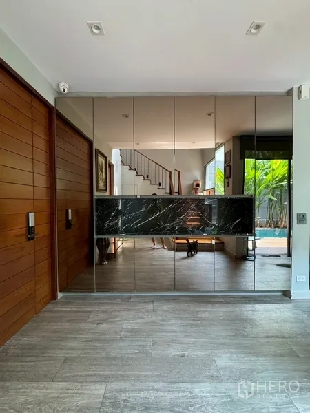 บ้านแฝด for rent in Watthana, Bangkok - โถงทางเข้าพร้อมผนังกระจกเงาสูงเต็มผนัง มองเห็นสระและบันได