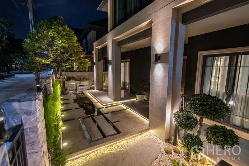 独立式住宅 出售在Pak Kret, Nonthaburi - 前庭景观，踏步石小径、水景与夜间庭院灯光。