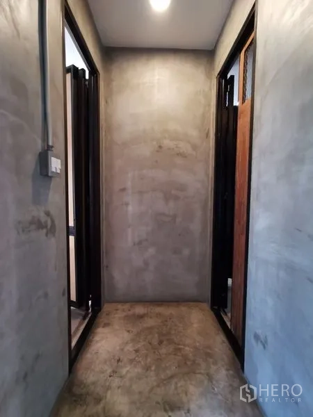 带办公室的家 出售在Wang Thonglang, Bangkok - 极简混凝土走廊，两侧为门洞。