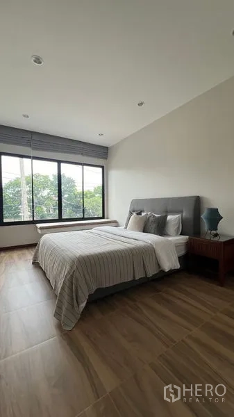 独立式住宅 出租在Lat Krabang, Bangkok - 主卧，宽幅窗户、木纹地砖与大床。