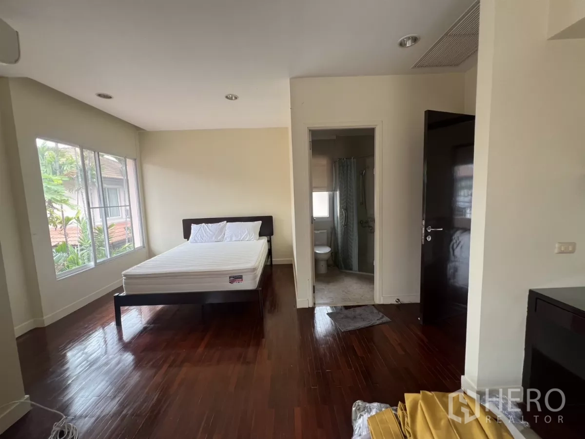 Detached House for rent in Wang Thonglang, Bangkok - Living area opening to the front garden through glass doors, TV wall and sofa.