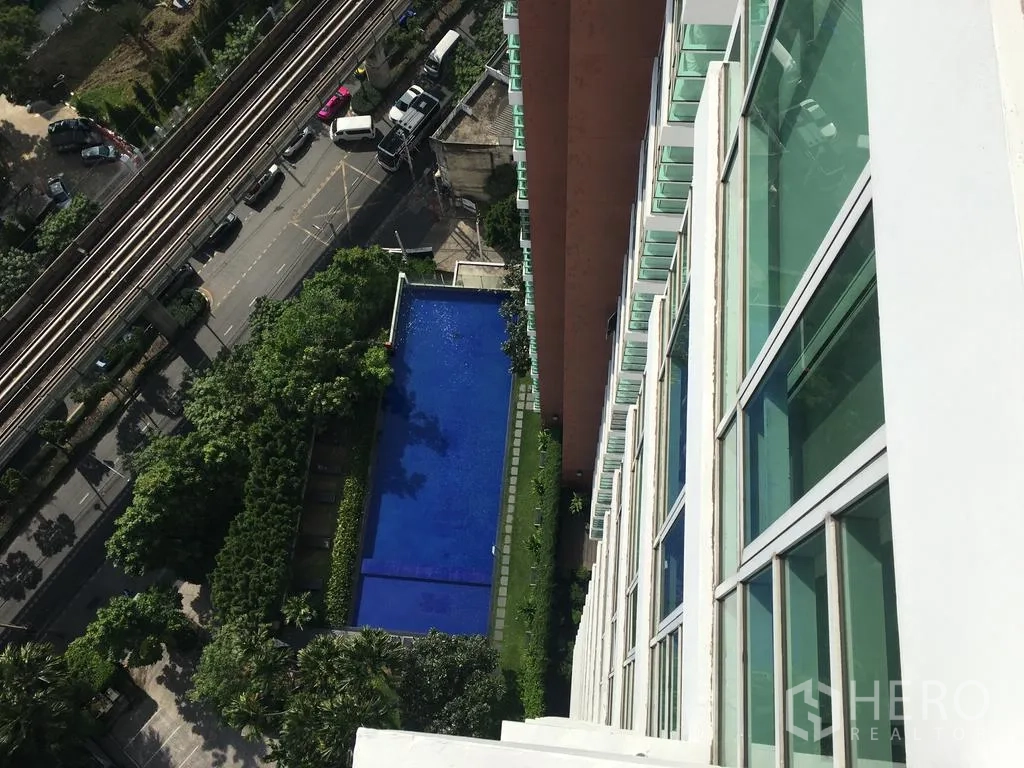 คอนโด ให้เช่าในWatthana, Bangkok - มุมสูงสระว่ายน้ำยาวกลางสวน และรางรถไฟฟ้า BTS ด้านล่าง
