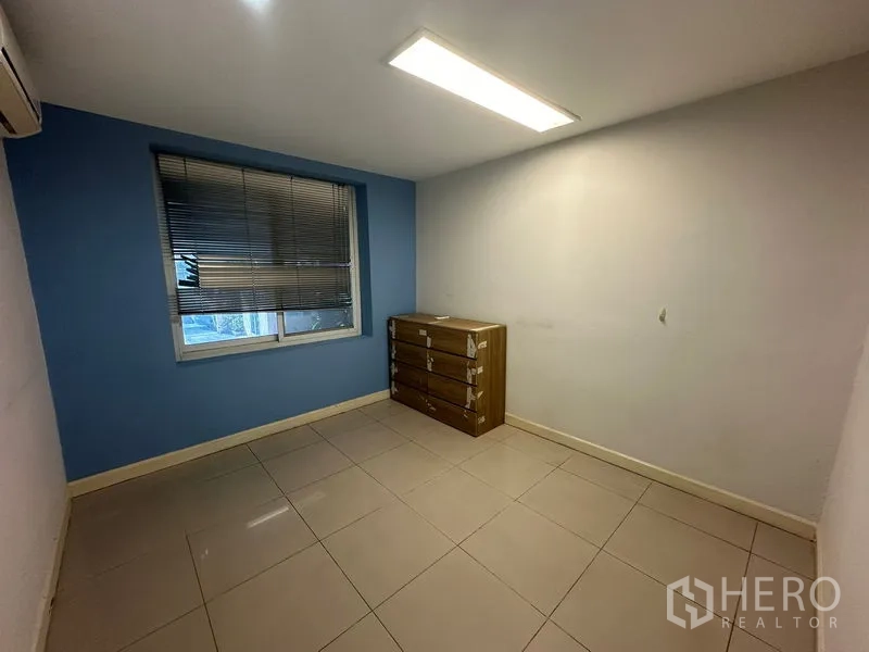 Office Space for sale - Small private office with blue accent wall, window blinds and filing drawers.