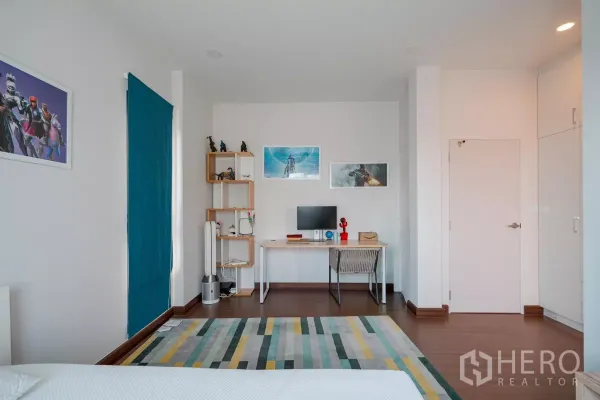 Detached House for sale in Saphan Sung, Bangkok - Bedroom study corner featuring a desk, open shelving and wall art.
