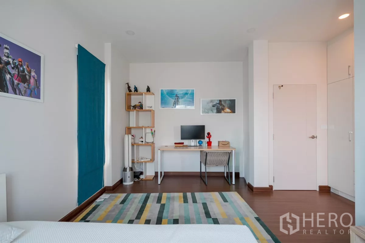 Detached House for sale in Saphan Sung, Bangkok - Bedroom study corner featuring a desk, open shelving and wall art.