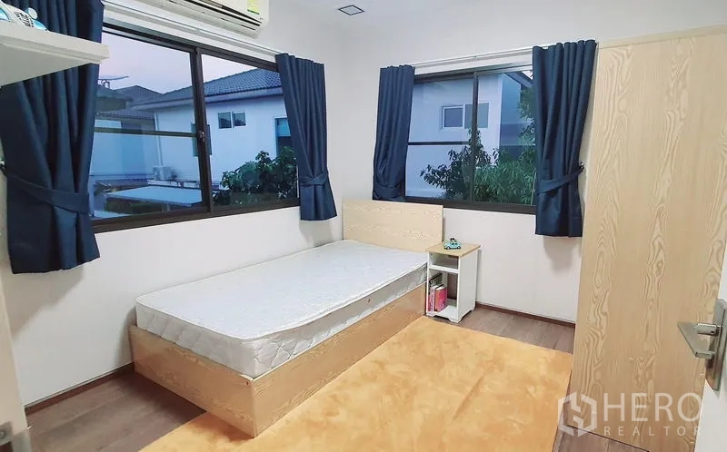 บ้าน ให้เช่าในBang Phli, Samut Prakan - ห้องนอนขนาดกะทัดรัด เตียงเดี่ยว ผ้าม่านสีน้ำเงิน หน้าต่างมุมห้อง