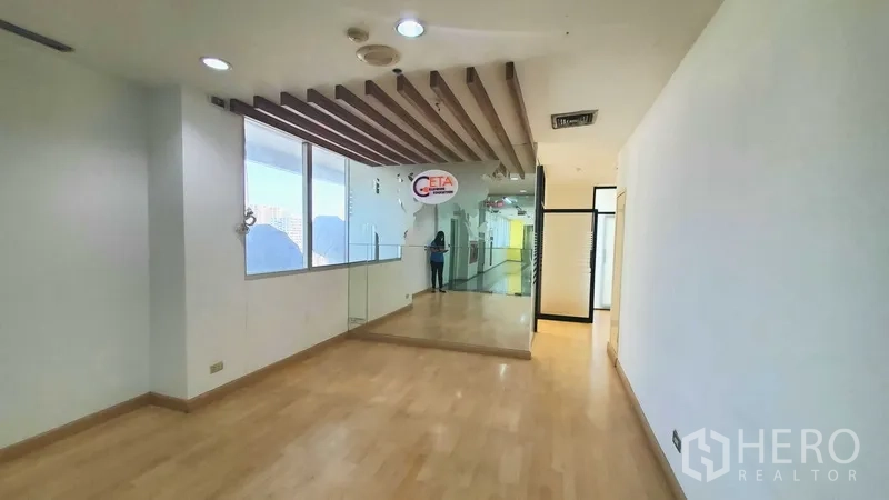 Office Space for rent in Khlong Toei, Bangkok - Reception corridor with wood flooring, ceiling slats, a large window, and city outlook.