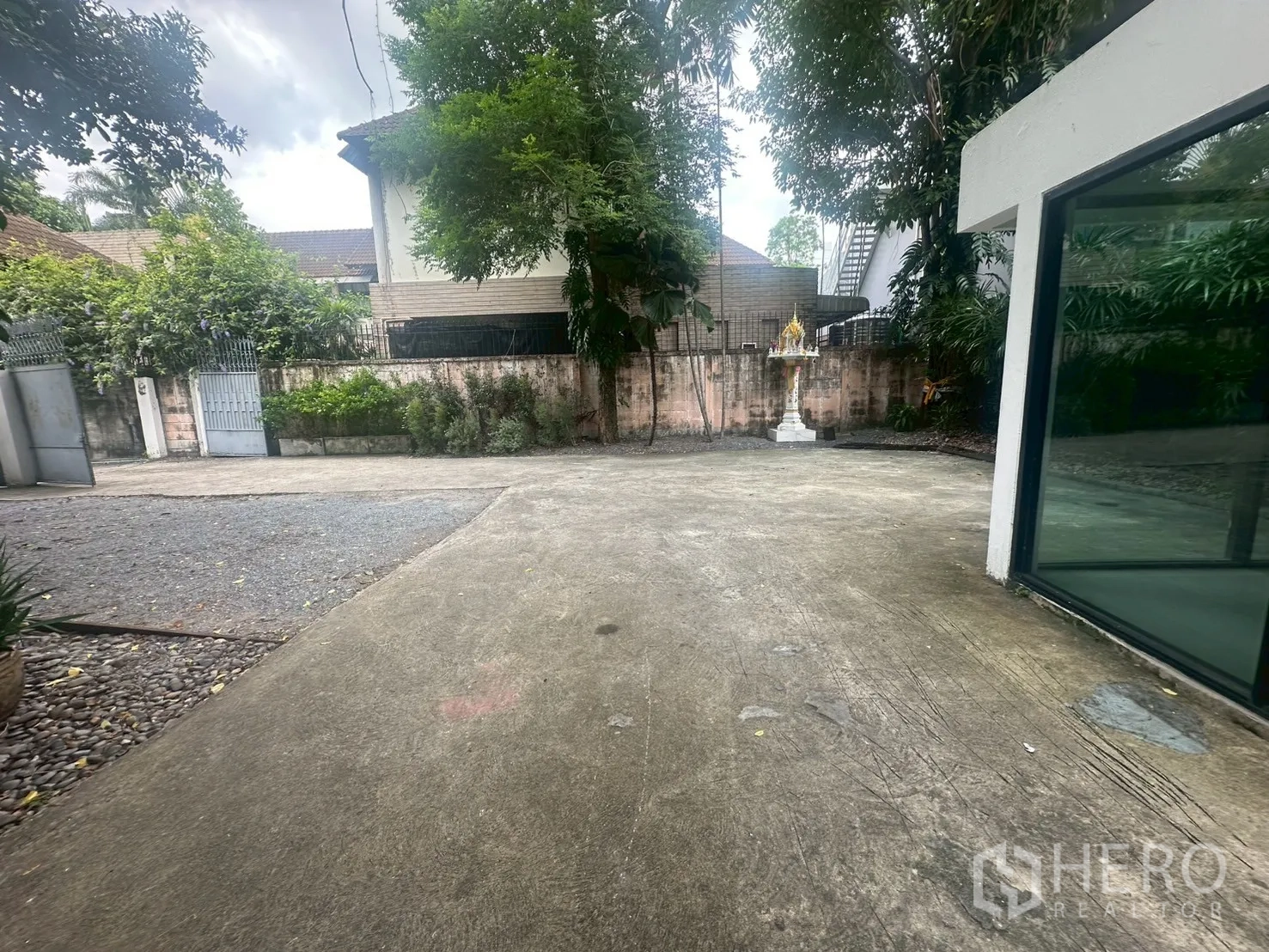 独立式住宅 出租在Watthana, Bangkok - 宽阔铺装车道与前院，通向大门。
