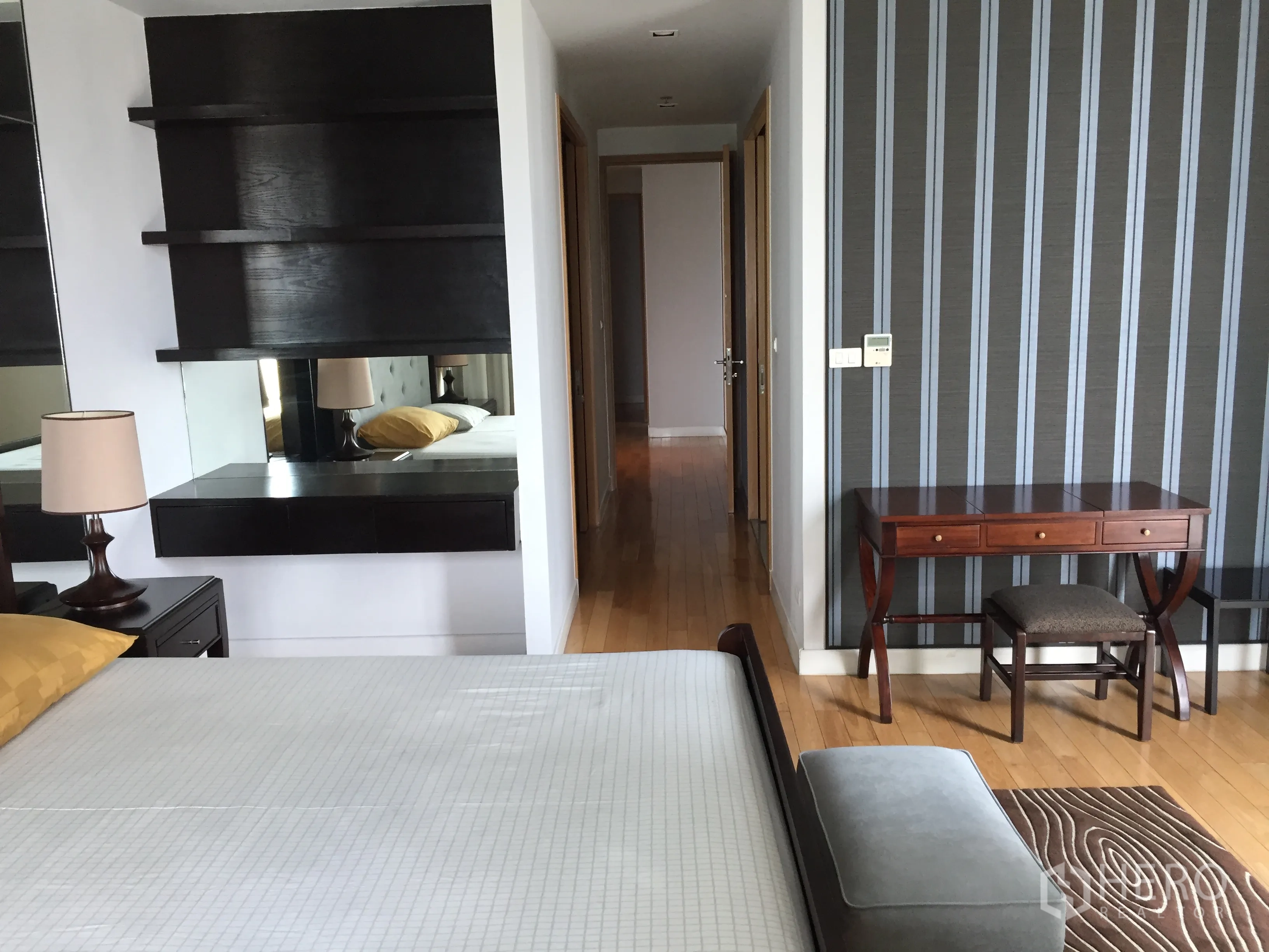 Condominium for rent or sale in Khlong Toei, Bangkok - Master bedroom view showing study desk, striped feature wall and hallway to ensuite.