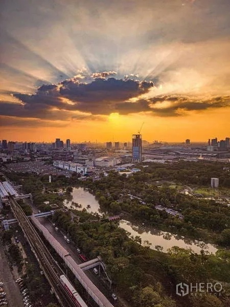 คอนโด ให้เช่า - ภาพพระอาทิตย์ตกเหนือนครกรุงเทพฯ เหนือสวน คลอง และแนวรถไฟฟ้า