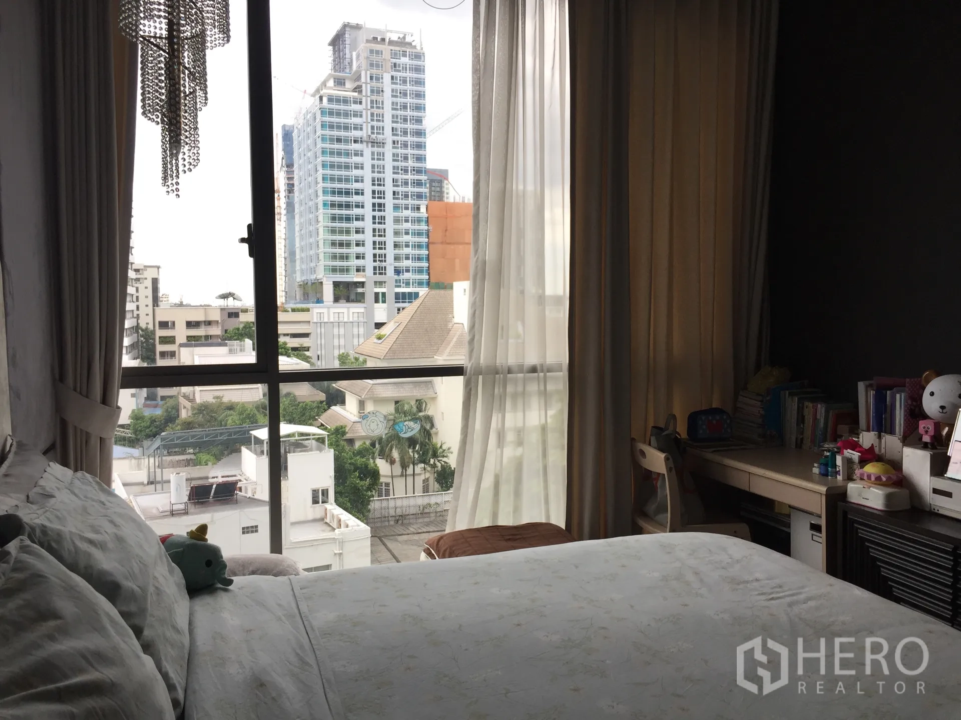 คอนโด ขายในWatthana, Bangkok - ห้องนอนอบอุ่นพร้อมเตียง โต๊ะทำงาน ผ้าม่านโปร่ง และหน้าต่างเต็มผนังมองเห็นวิวเมือง