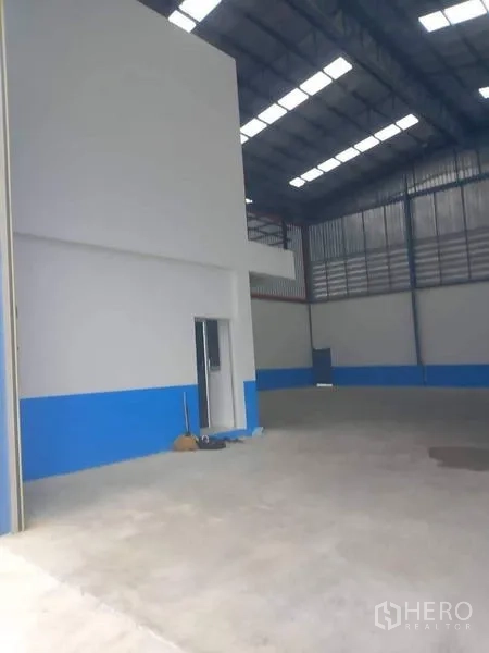 Warehouse for rent in Bang Phli, Samut Prakan - Open warehouse floor with mezzanine section and high ceiling for storage.
