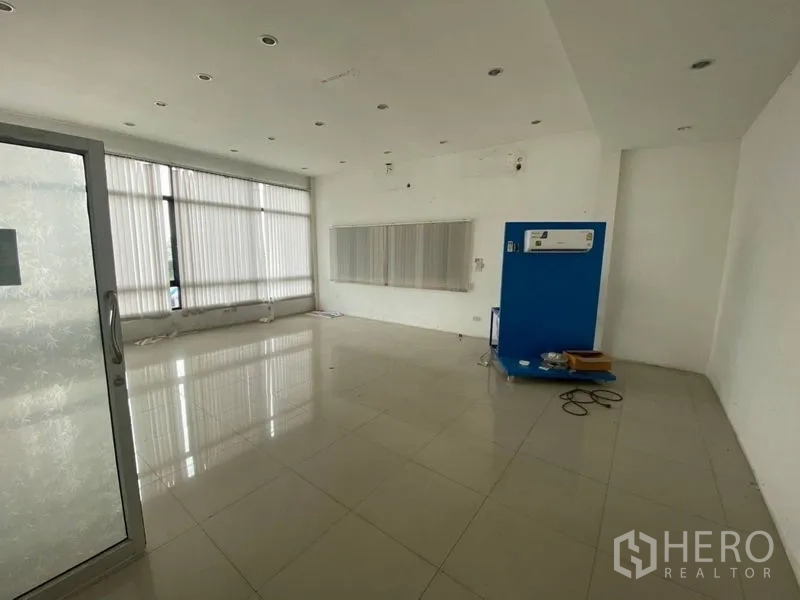 Factory for rent or sale in Lam Luk Ka, Pathum Thani - Bright office space with large windows, vertical blinds and wall-mounted AC.