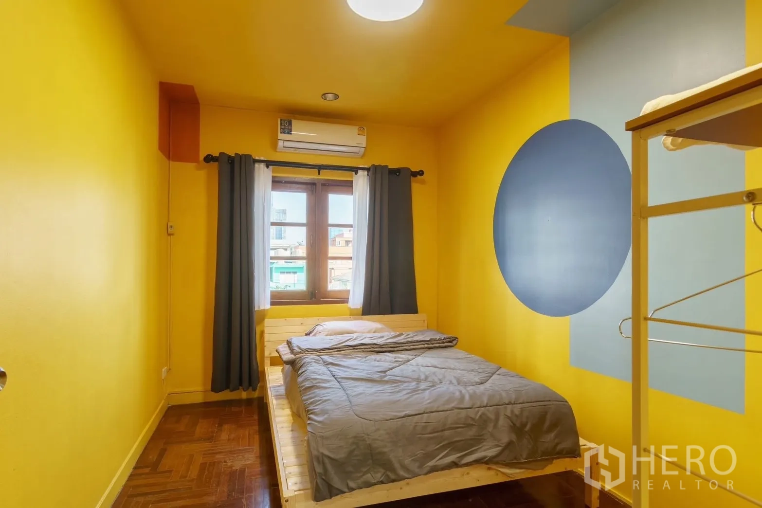 ทาวน์เฮาส์ for rent in Watthana, Bangkok - ห้องนอนโทนสีเหลืองขนาดกะทัดรัด เตียงคู่ หน้าต่าง และแอร์ผนัง