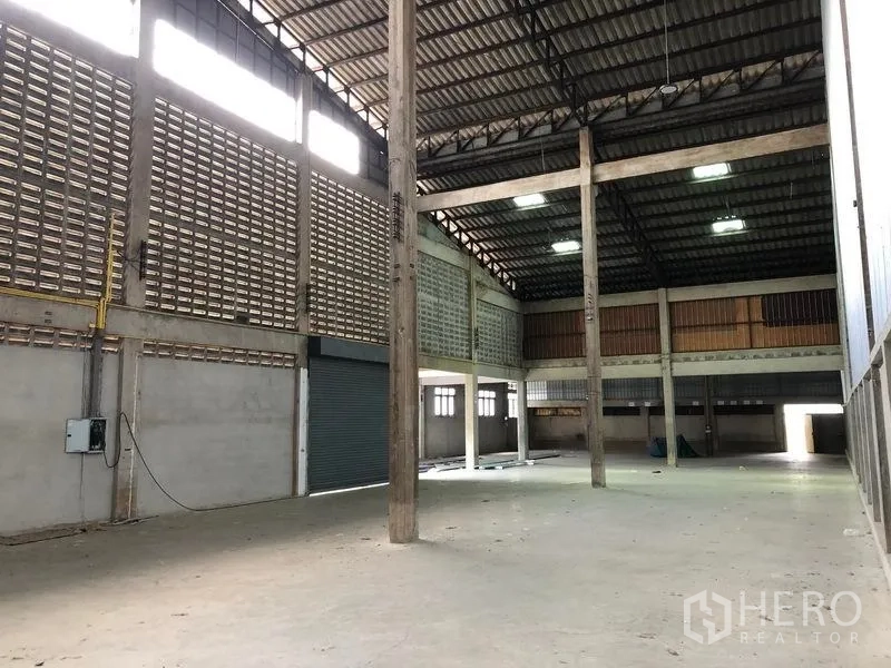 货栈 出租在Pathum Thani - 宽敞工业空间，高屋顶、通风墙与卷帘门。