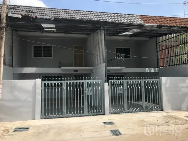 带办公室的家 出租在Phra Khanong, Bangkok - 两层联排式家庭办公楼外观，双重金属大门与有顶停车位，瓦片屋顶。