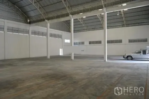 Warehouse for rent in Samut Sakhon - Open storage space showing high clearance, wide concrete floor and roll-up door area.