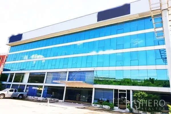 Office Space for rent in Suan Luang, Bangkok - Full exterior view of the glazed commercial building with wide windows and entrance canopy.