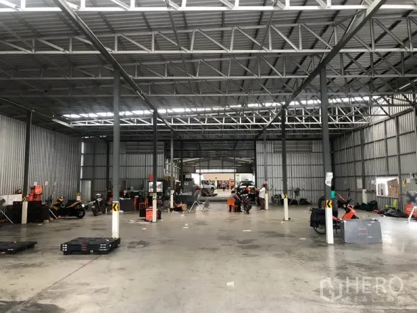 货栈 出租在Don Mueang, Bangkok - 仓库内部宽敞，钢结构桁架，开阔混凝土地面与长条照明。