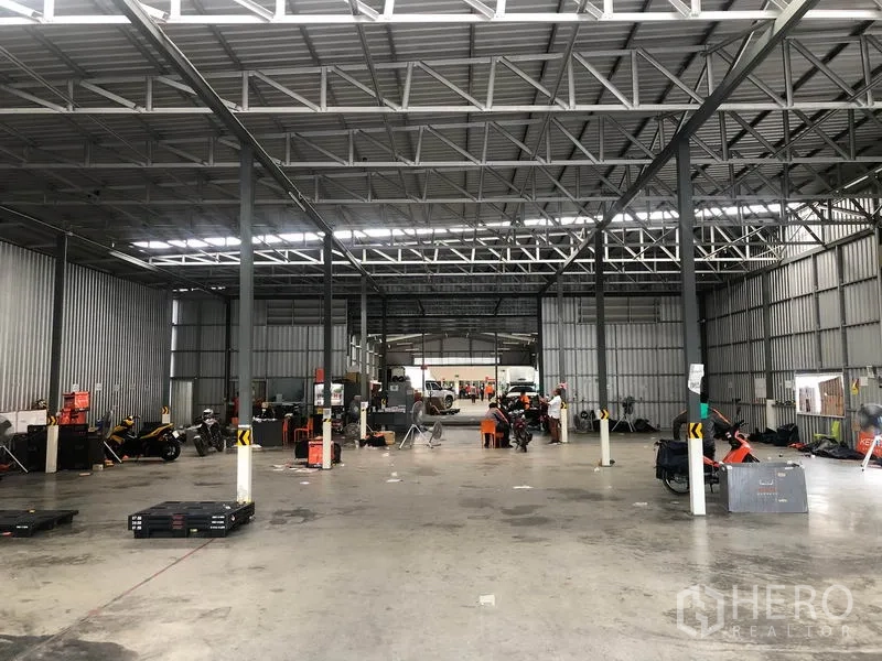 货栈 出租在Don Mueang, Bangkok - 仓库内部宽敞，钢结构桁架，开阔混凝土地面与长条照明。