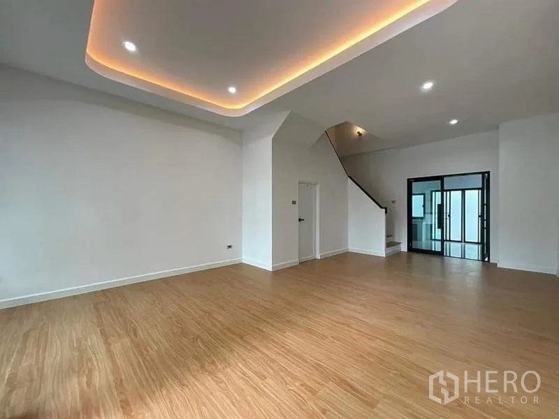 ทาวน์เฮาส์ ขายในWatthana, Bangkok - ห้องรับแขกกว้าง ฝ้าซ่อนไฟ บันได และประตูกระจกบานเลื่อน